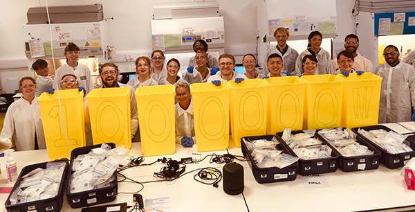 Volunteer researchers celebrating the processing of one million tests